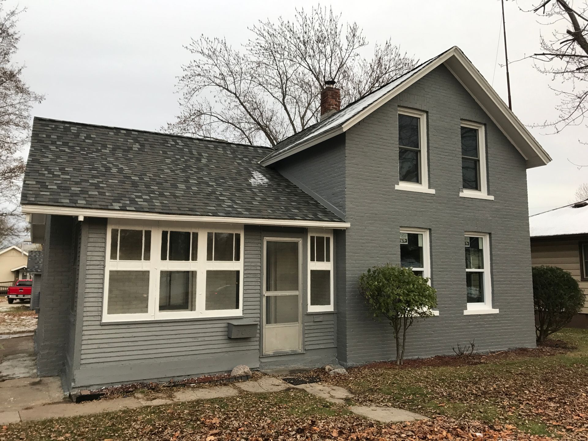 A gray house with white windows and a gray roof