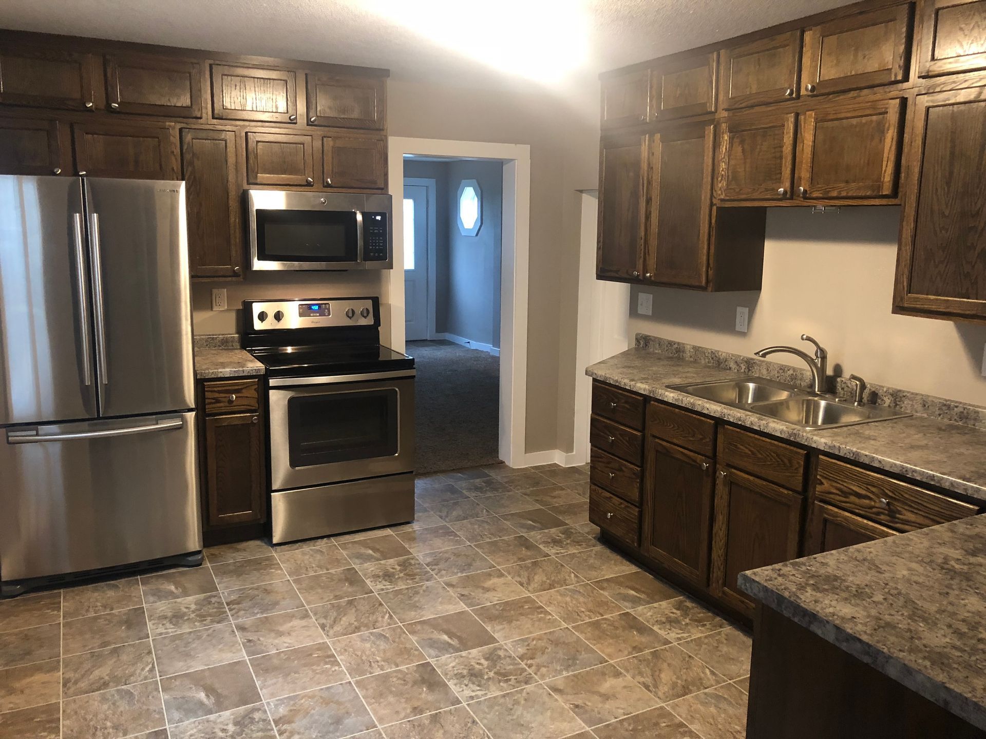 A kitchen with stainless steel appliances and wooden cabinets.