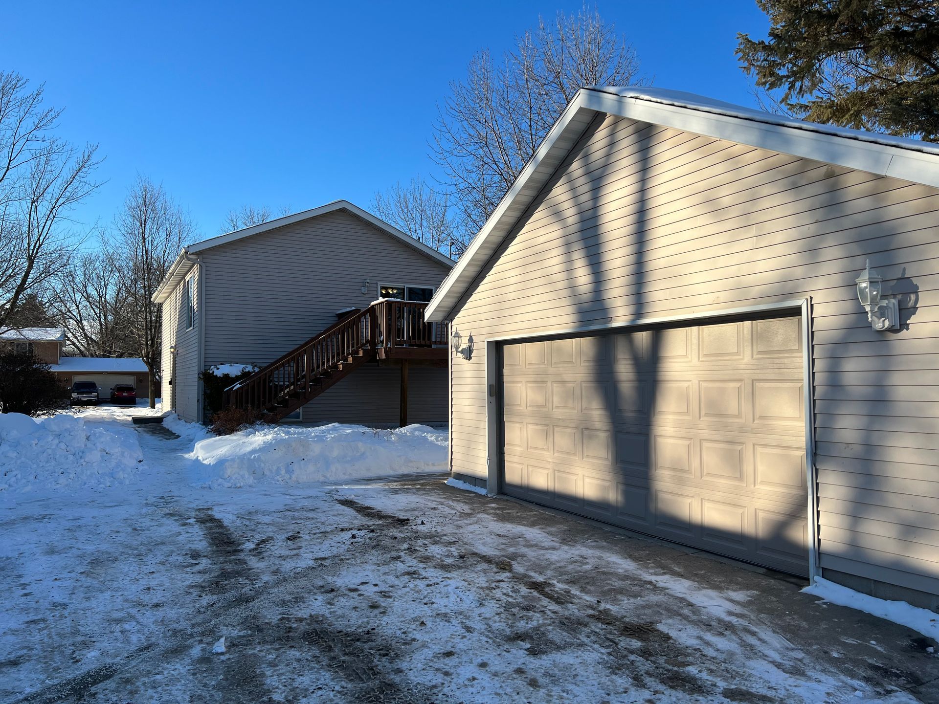 A house with a garage and stairs in the snow