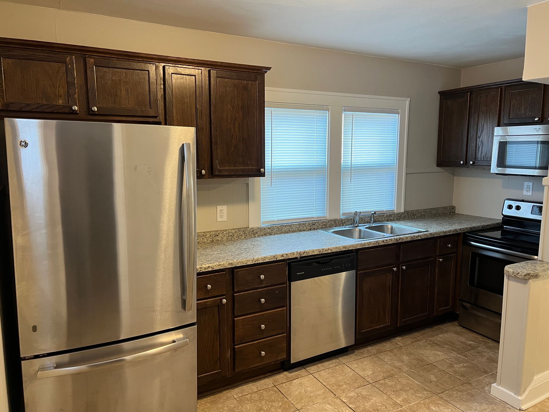 A kitchen with stainless steel appliances and wooden cabinets.