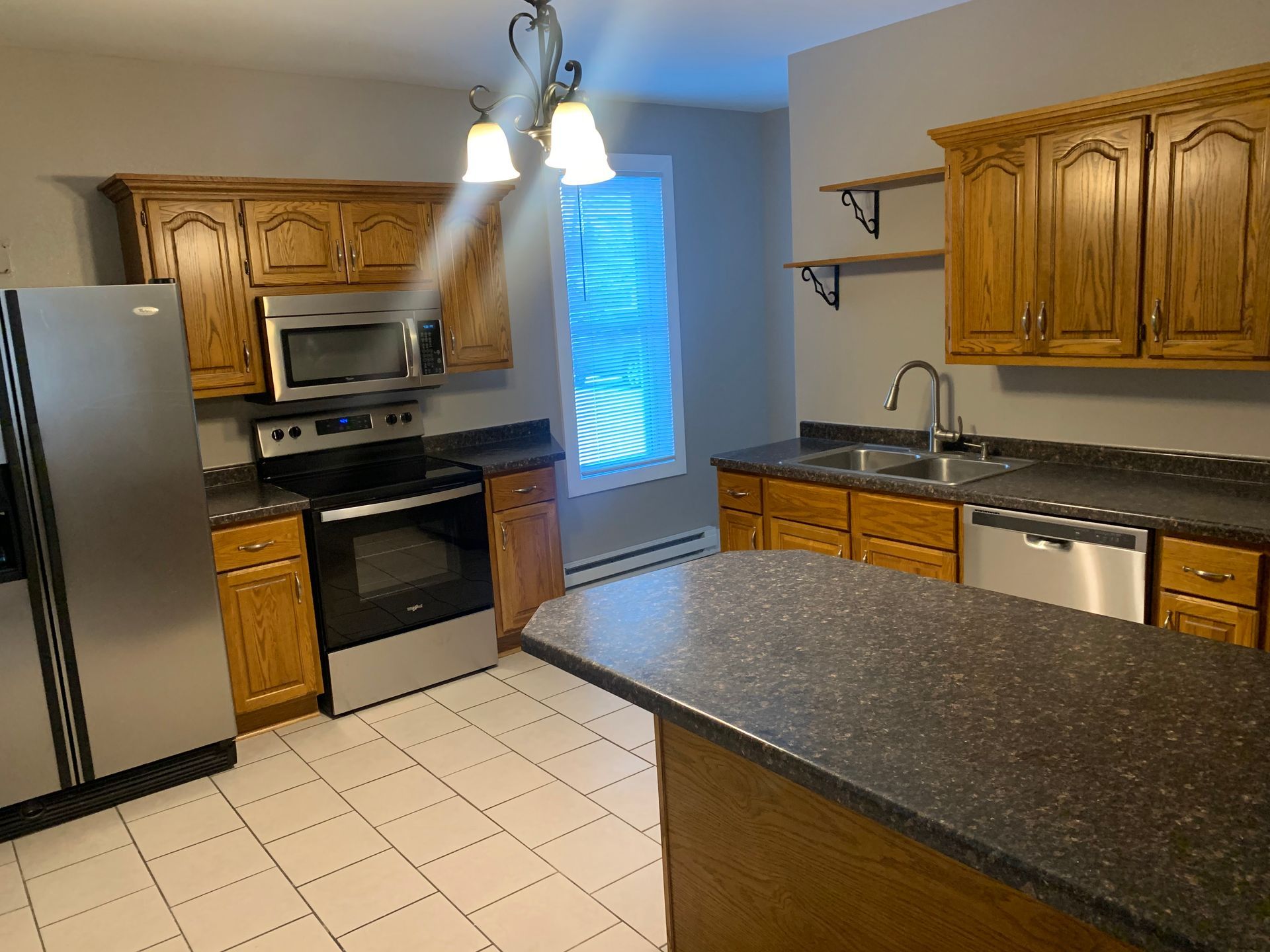 A kitchen with stainless steel appliances and wooden cabinets