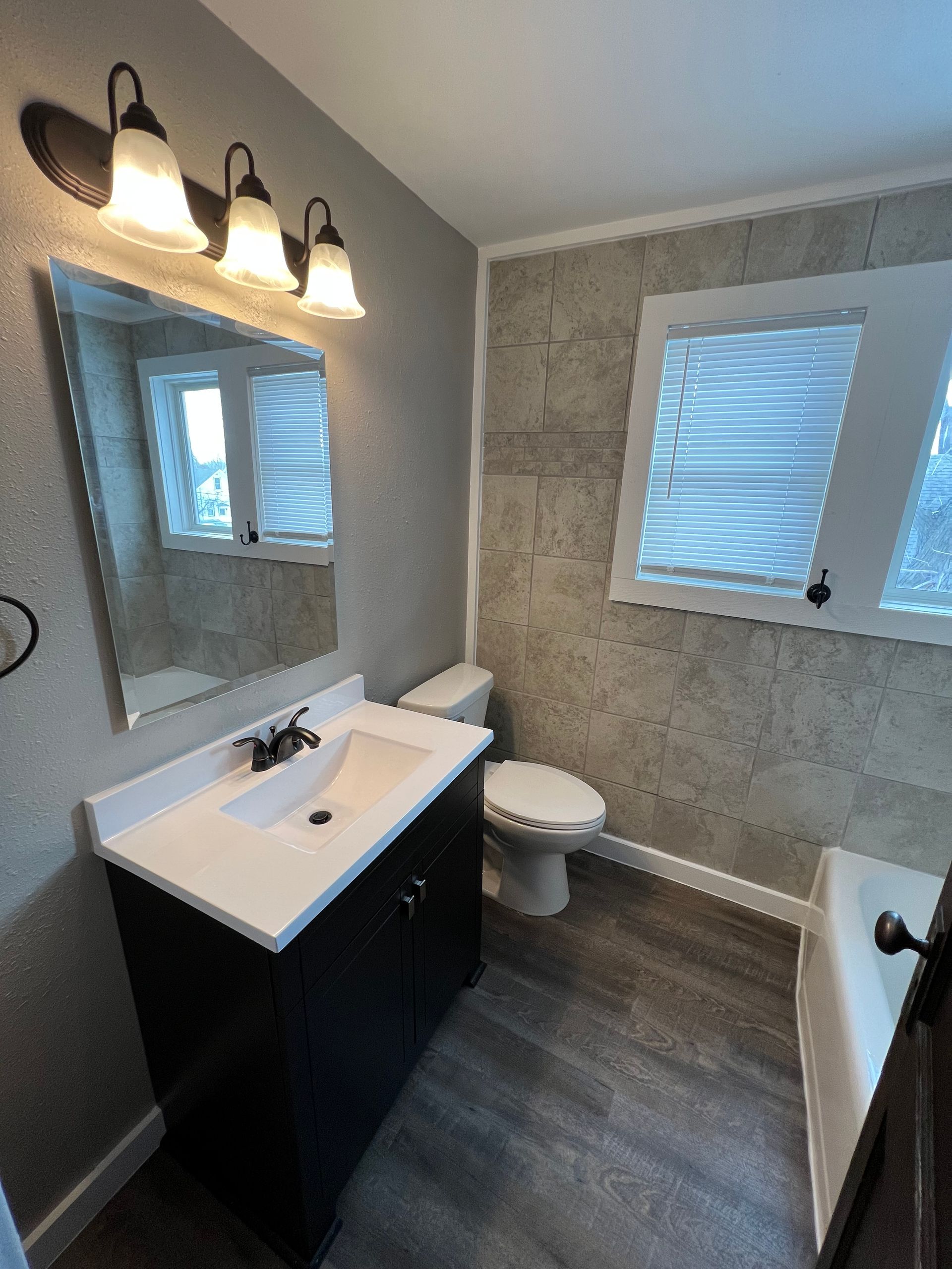 A bathroom with a sink , toilet , and mirror.