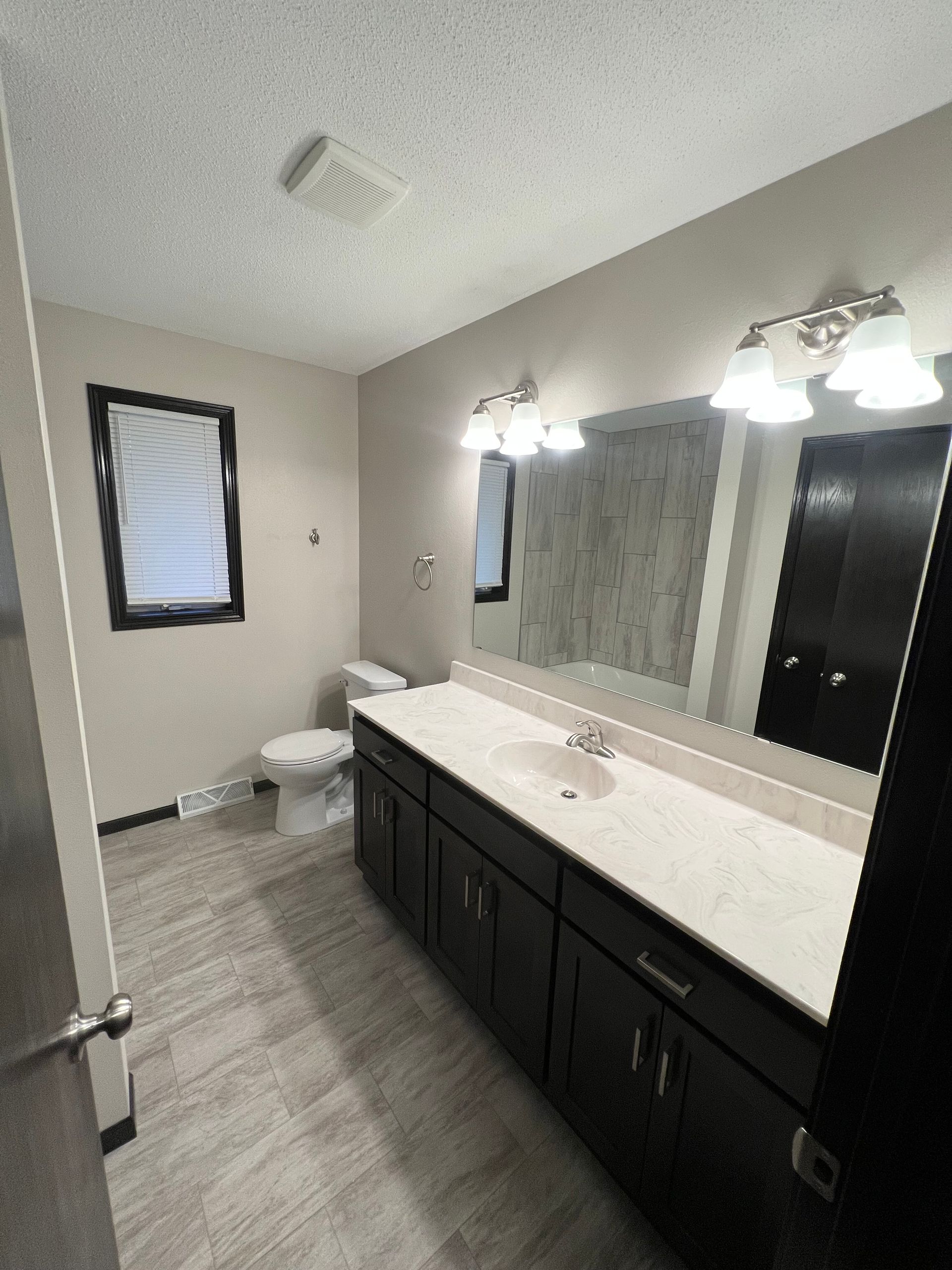A bathroom with a toilet , sink and mirror