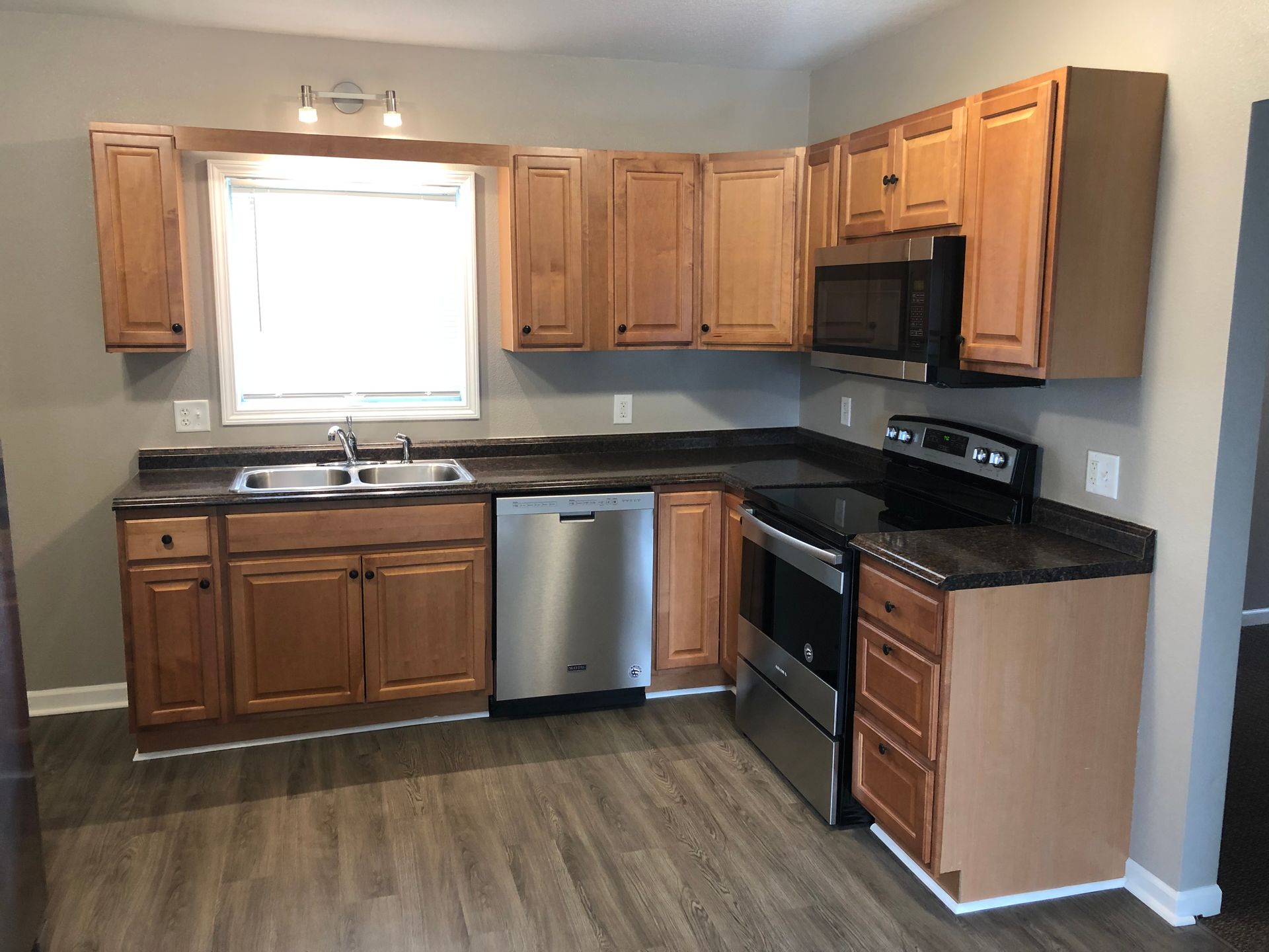 A kitchen with wooden cabinets and stainless steel appliances.