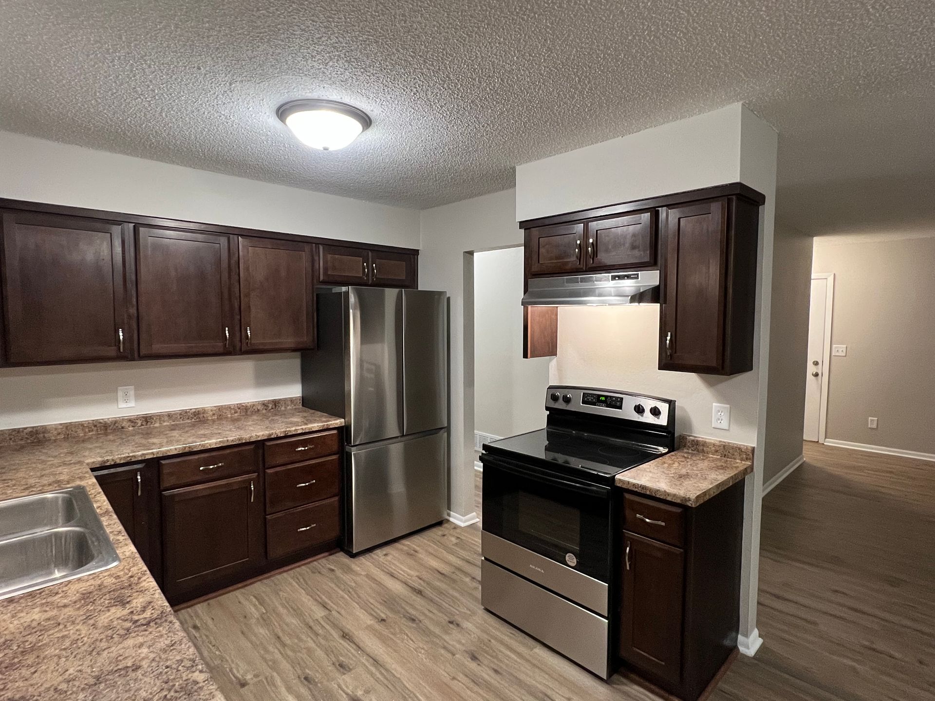 A kitchen with stainless steel appliances and wooden cabinets.