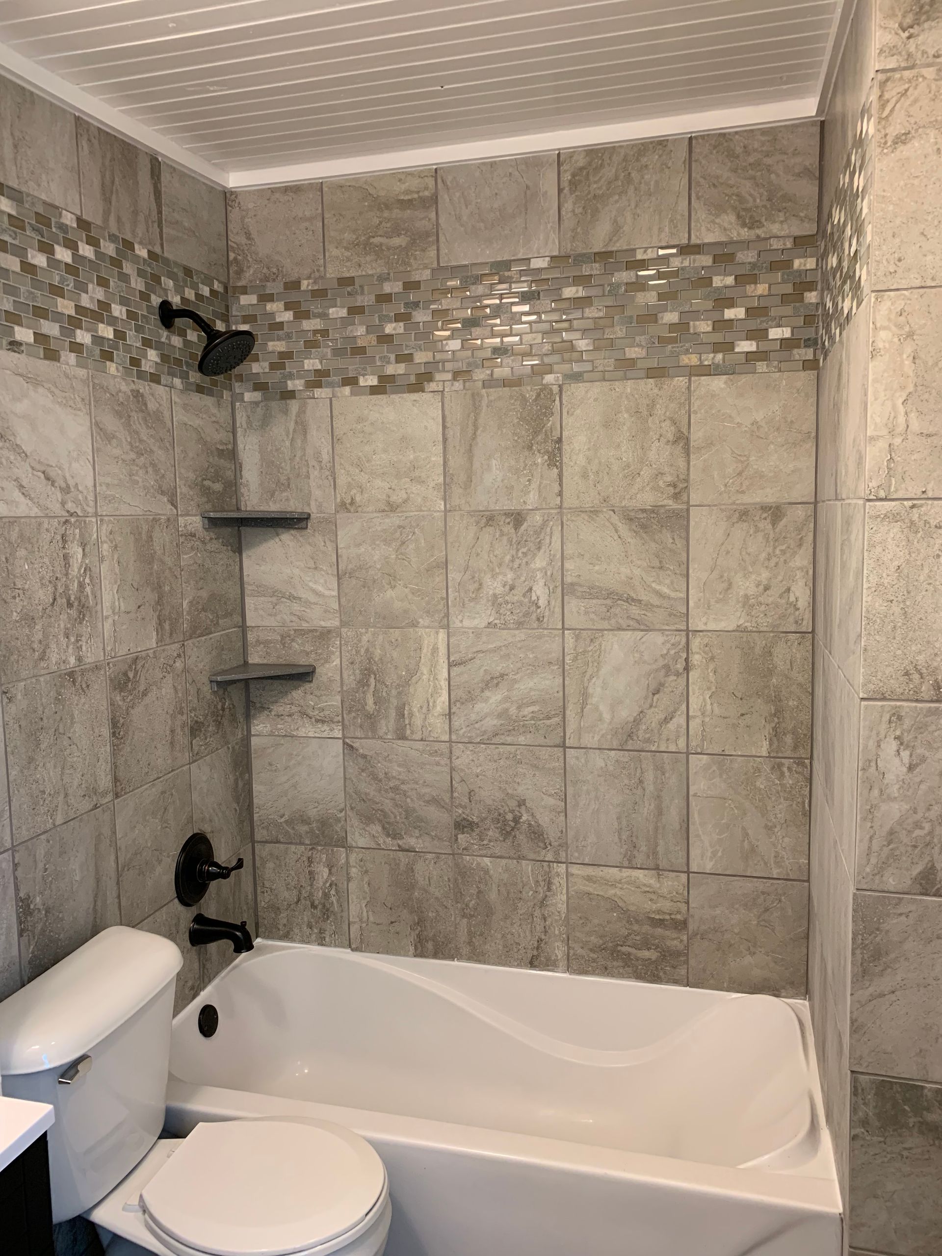 A bathroom with a tub , toilet and shower.