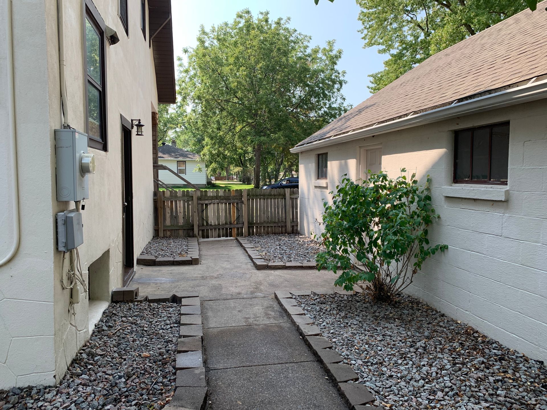 A house with a fence and a walkway leading to it