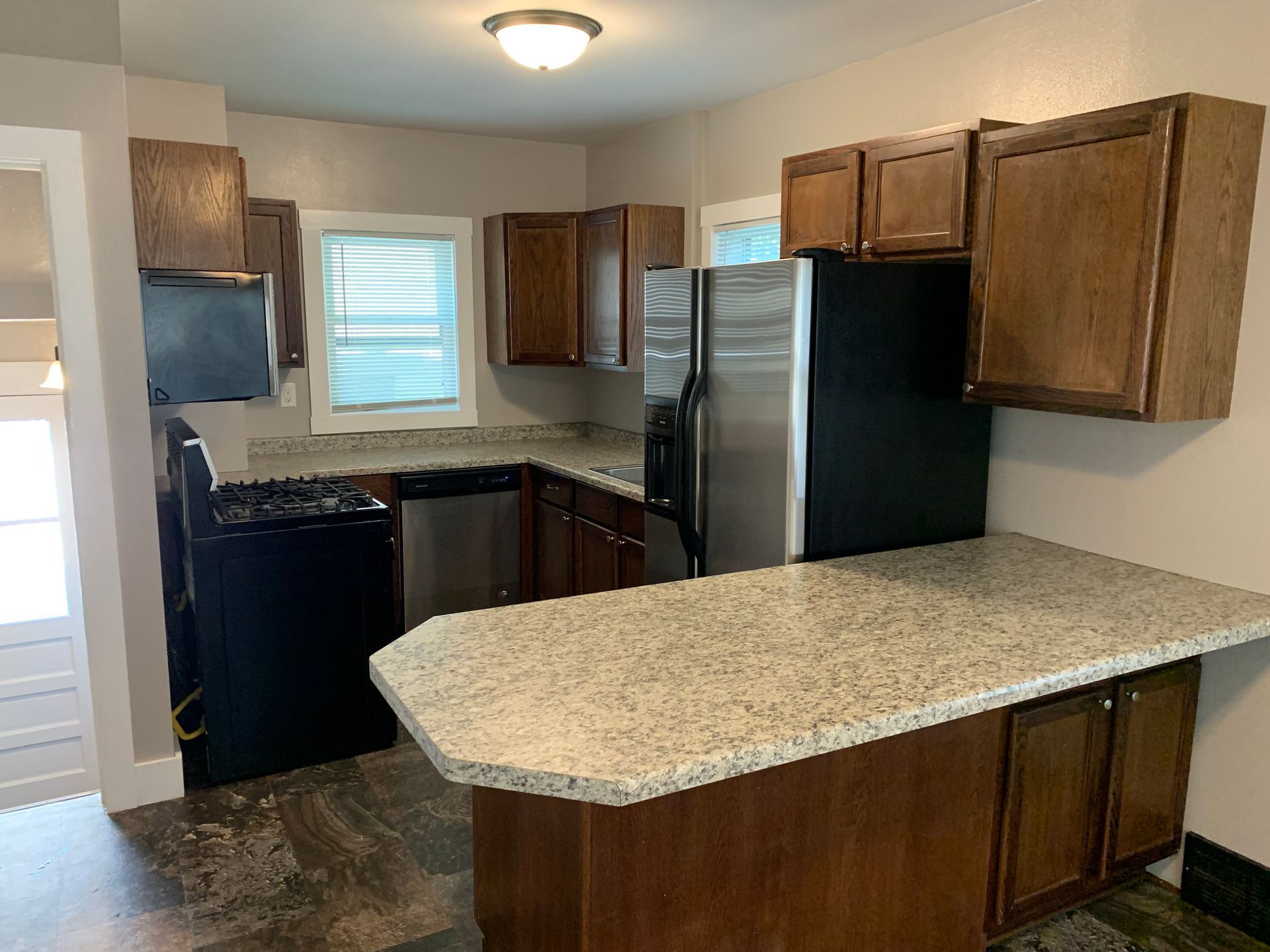 A kitchen with stainless steel appliances and granite counter tops.