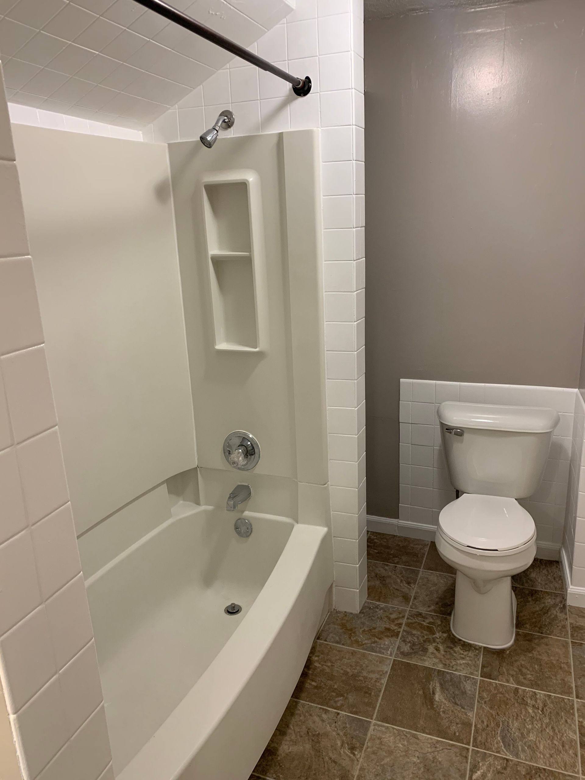 A bathroom with a tub , toilet and shower.