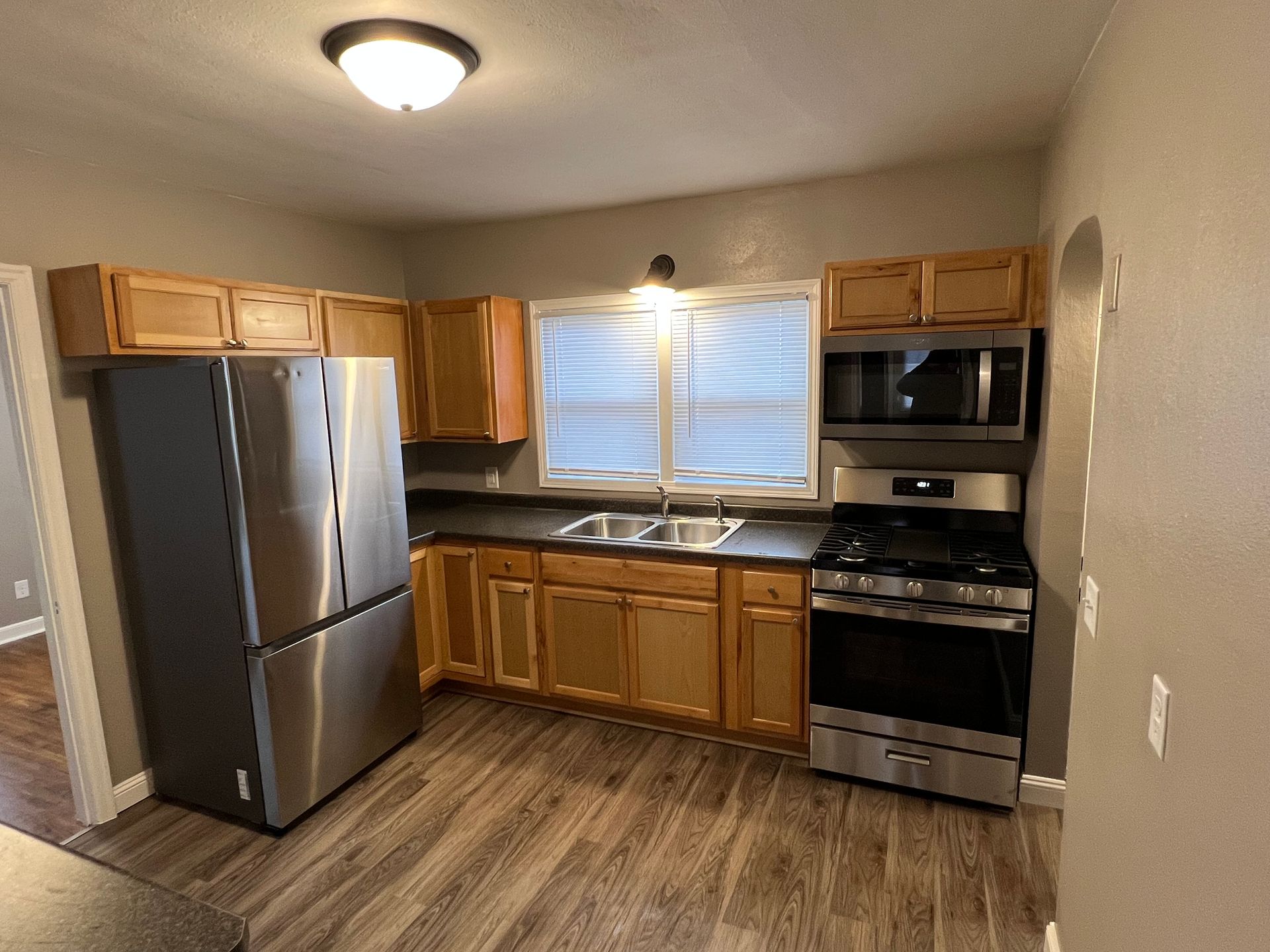 A kitchen with stainless steel appliances and wooden cabinets.