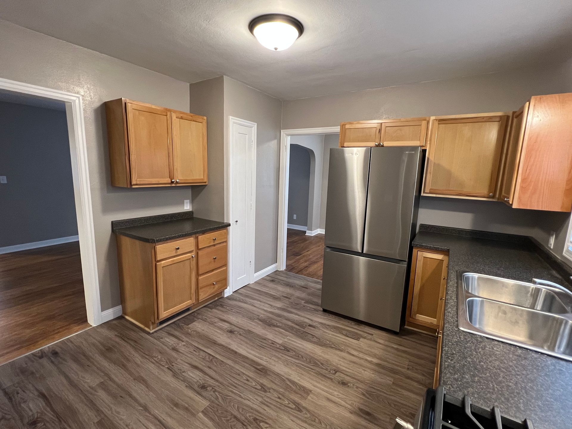 A kitchen with stainless steel appliances and wooden cabinets.