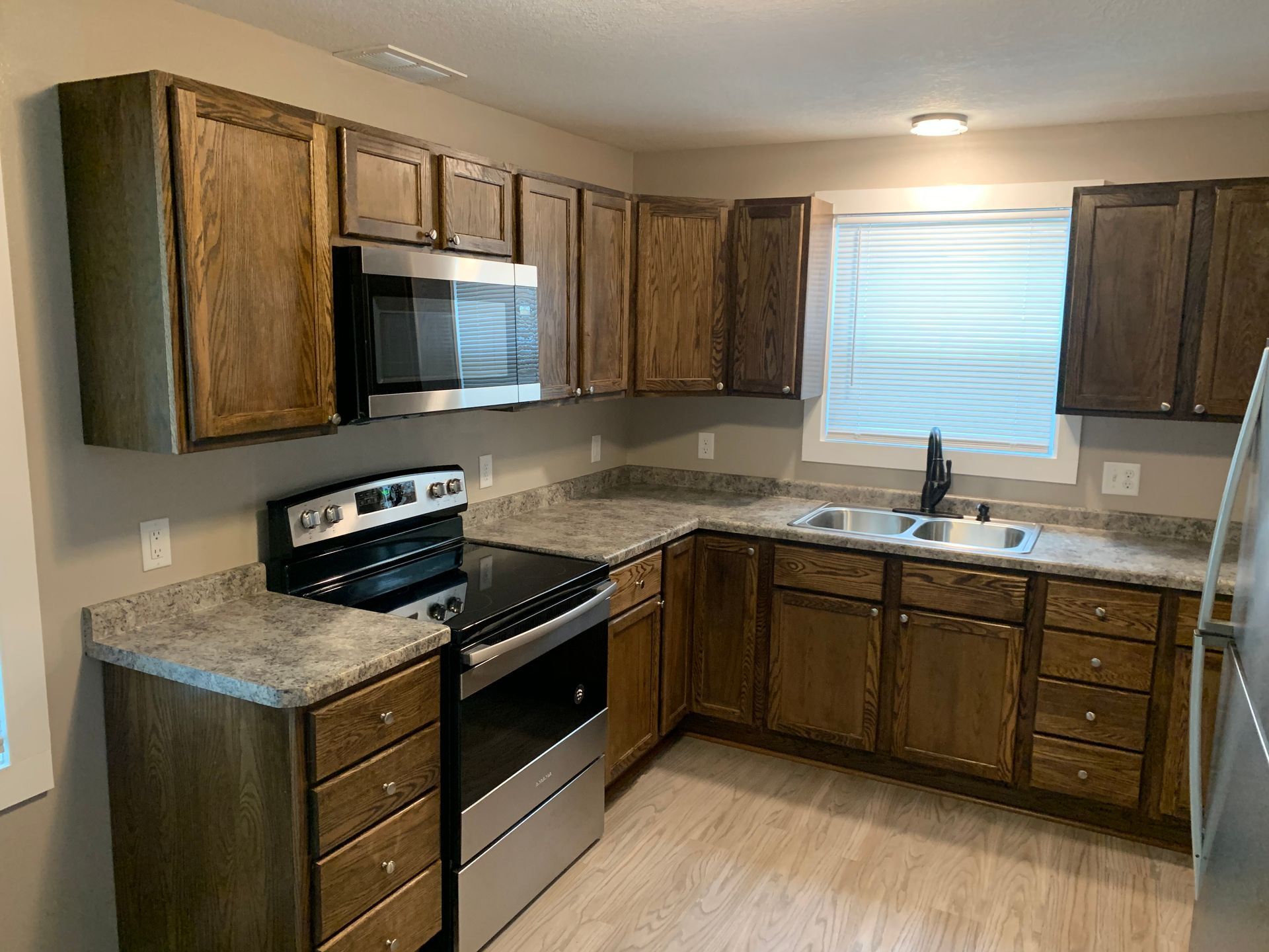 A kitchen with stainless steel appliances and wooden cabinets.