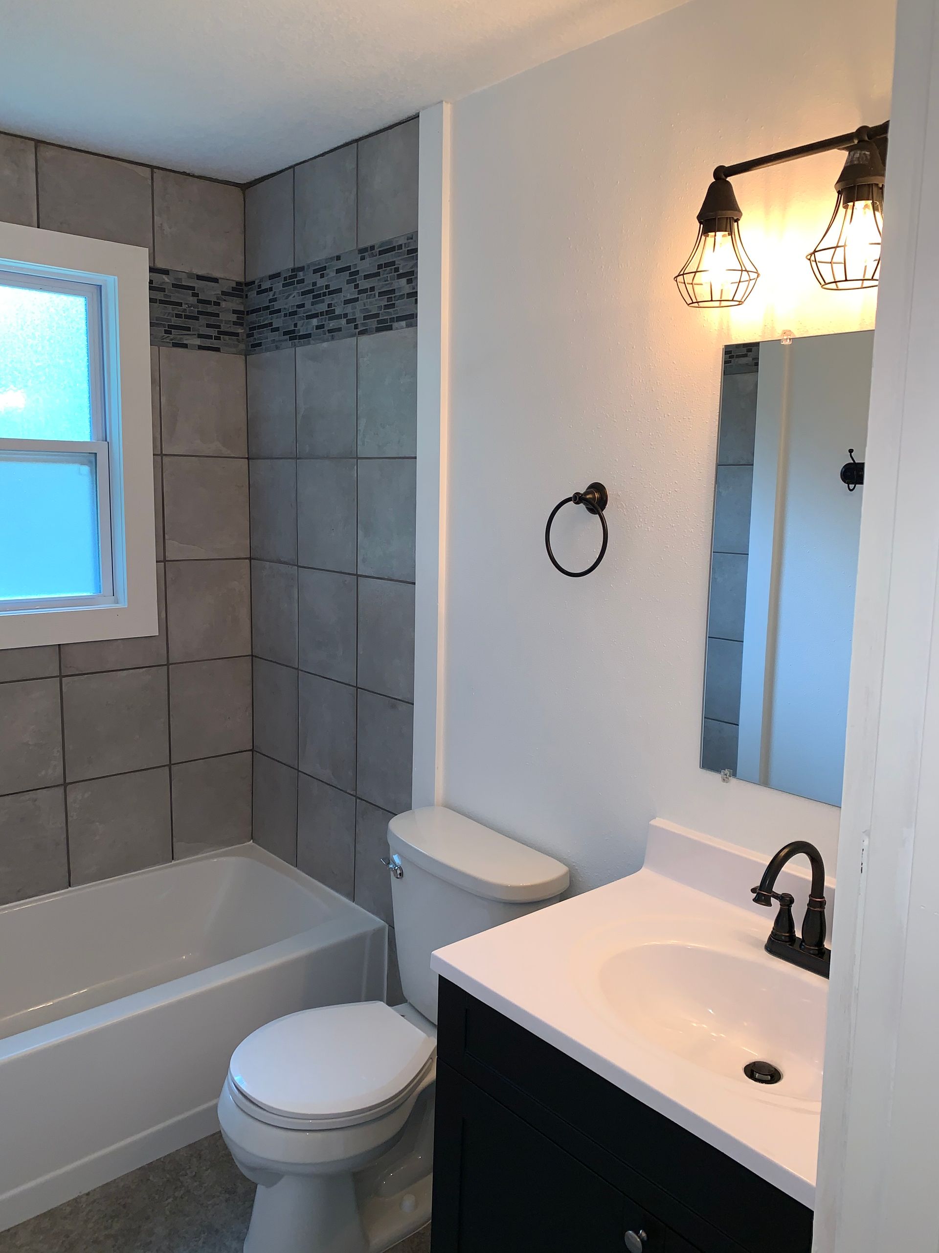 A bathroom with a toilet , sink and bathtub