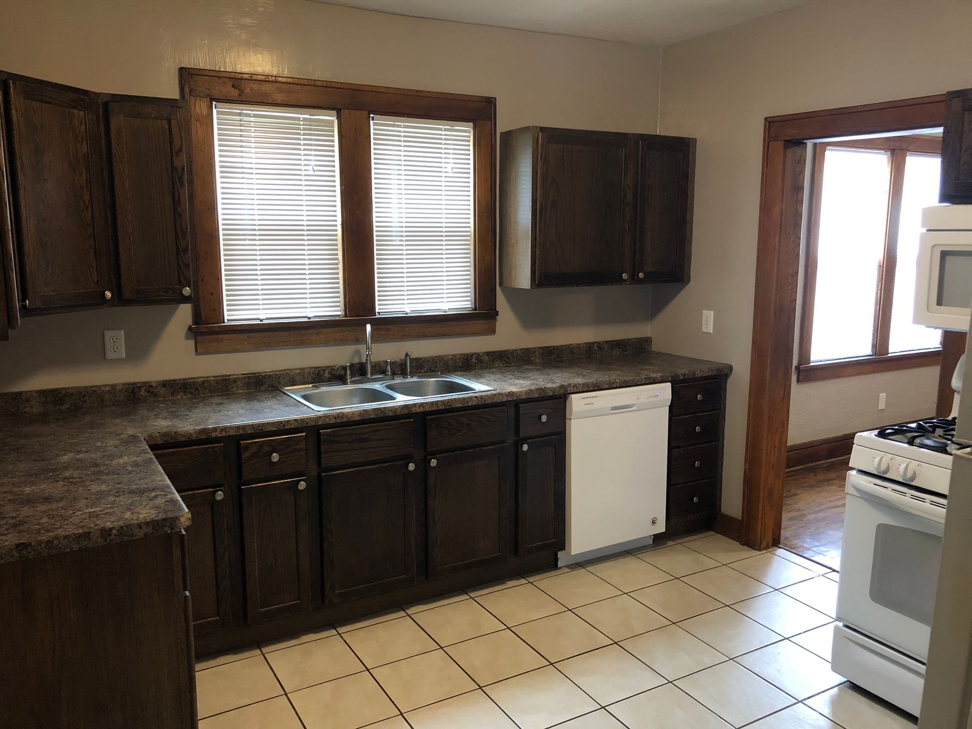 A kitchen with brown cabinets and white appliances