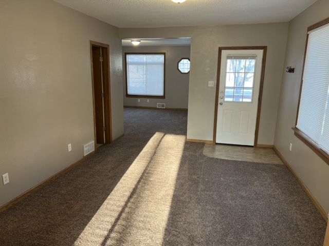 An empty living room with a couch and a door