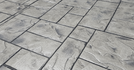 Stamped concrete with a large stone paver pattern in light gray