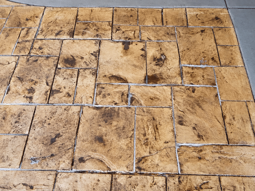 Stamped concrete with a tan slate-style pattern and defined grout lines