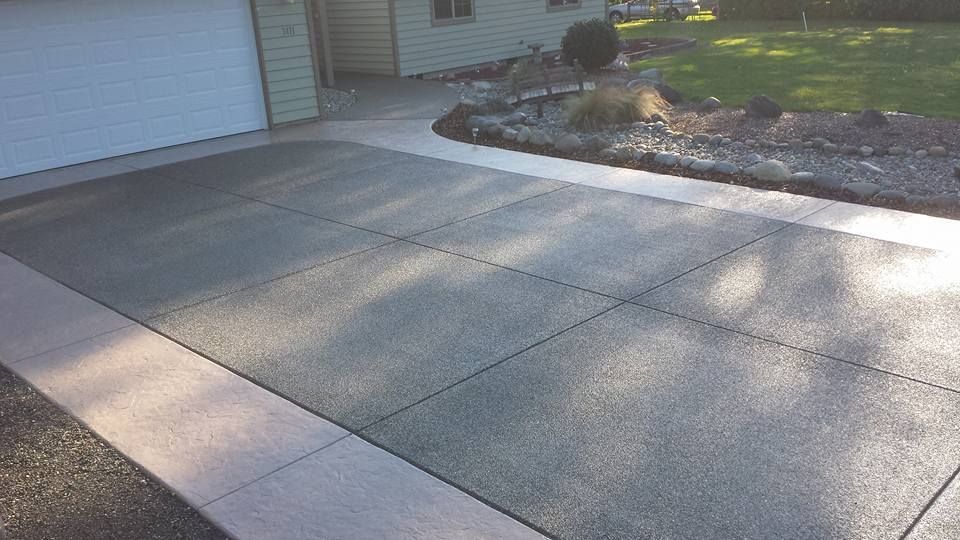 Finished concrete driveway project with decorative perimeter accents