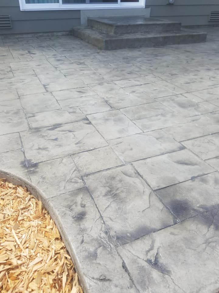 Stamped concrete patio with ashlar stone pattern and raised entry step
