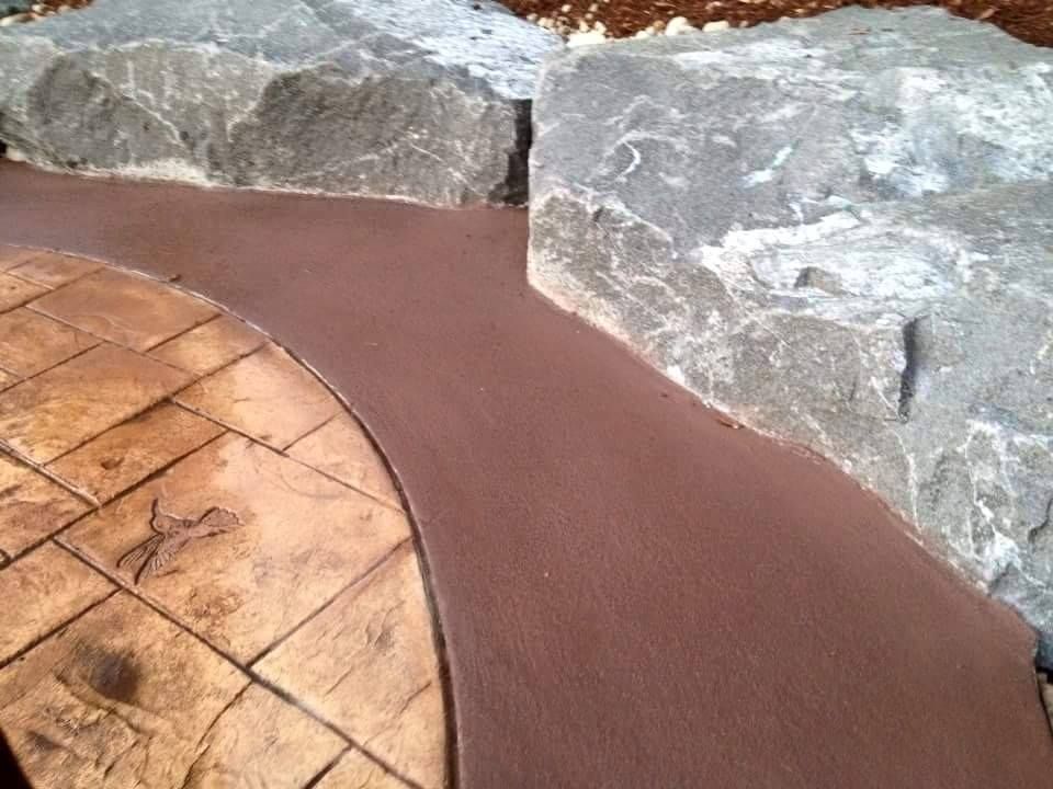 Decorative backyard concrete featuring stone pattern and accent band