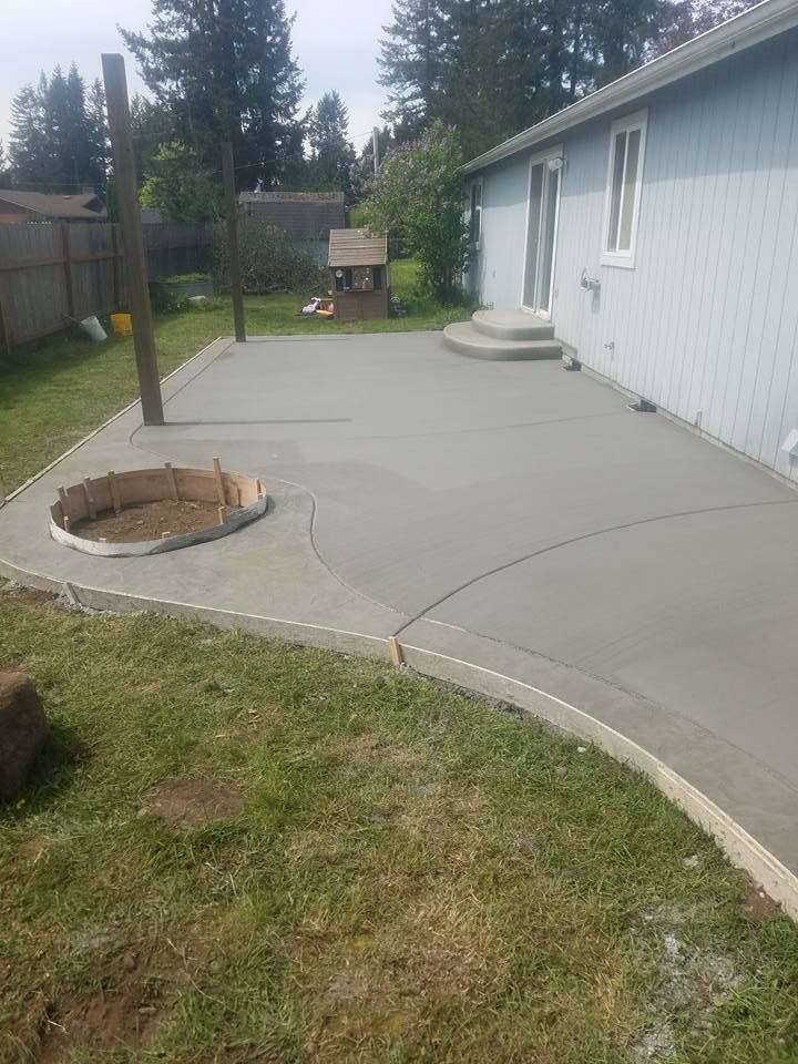 Backyard concrete patio installation with smooth broom finish
