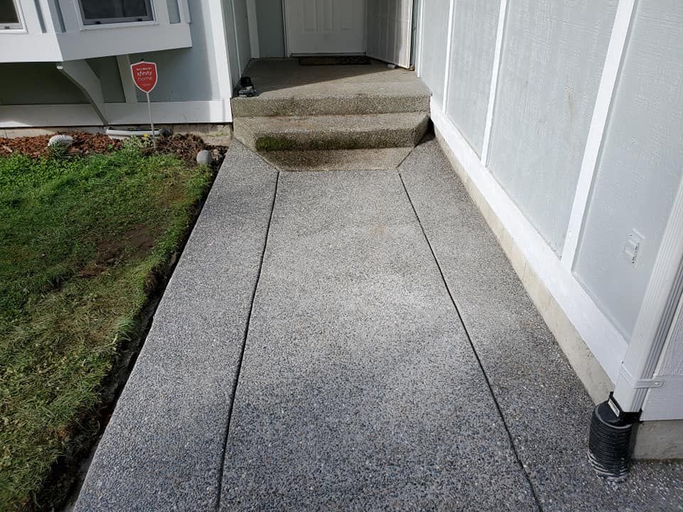 Exposed aggregate concrete walkway leading to front entry steps