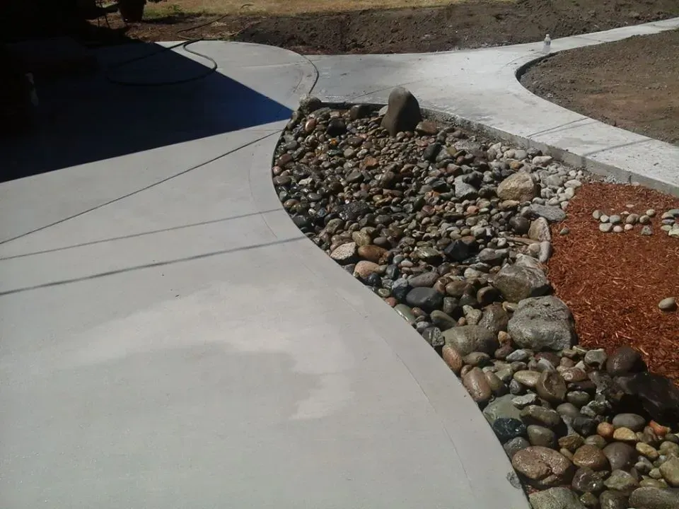 Concrete walkway design with natural stone drainage bed