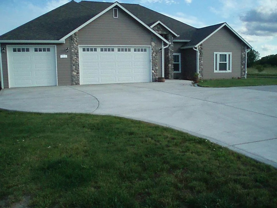 Custom concrete driveway with double garage entry and curved edge detail in Toledo, Wa