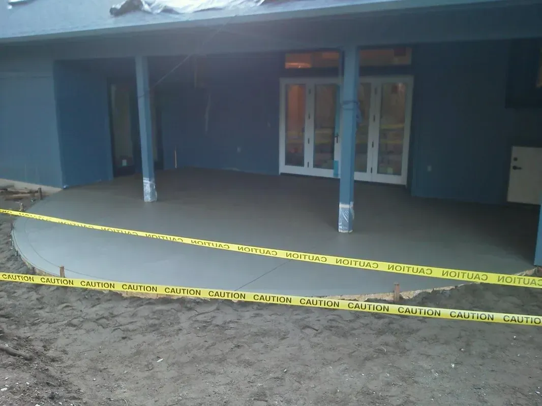 Freshly poured concrete patio under covered outdoor living area
