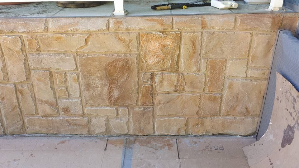 Residential stamped concrete wall installation detail
