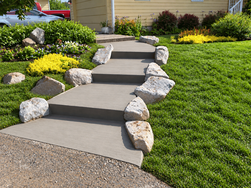 Concrete steps with natural stone edging down a landscaped slope