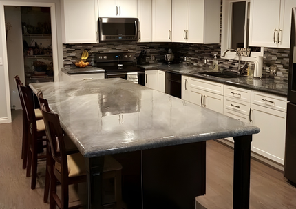 Custom concrete kitchen island countertop with seating and white cabinets