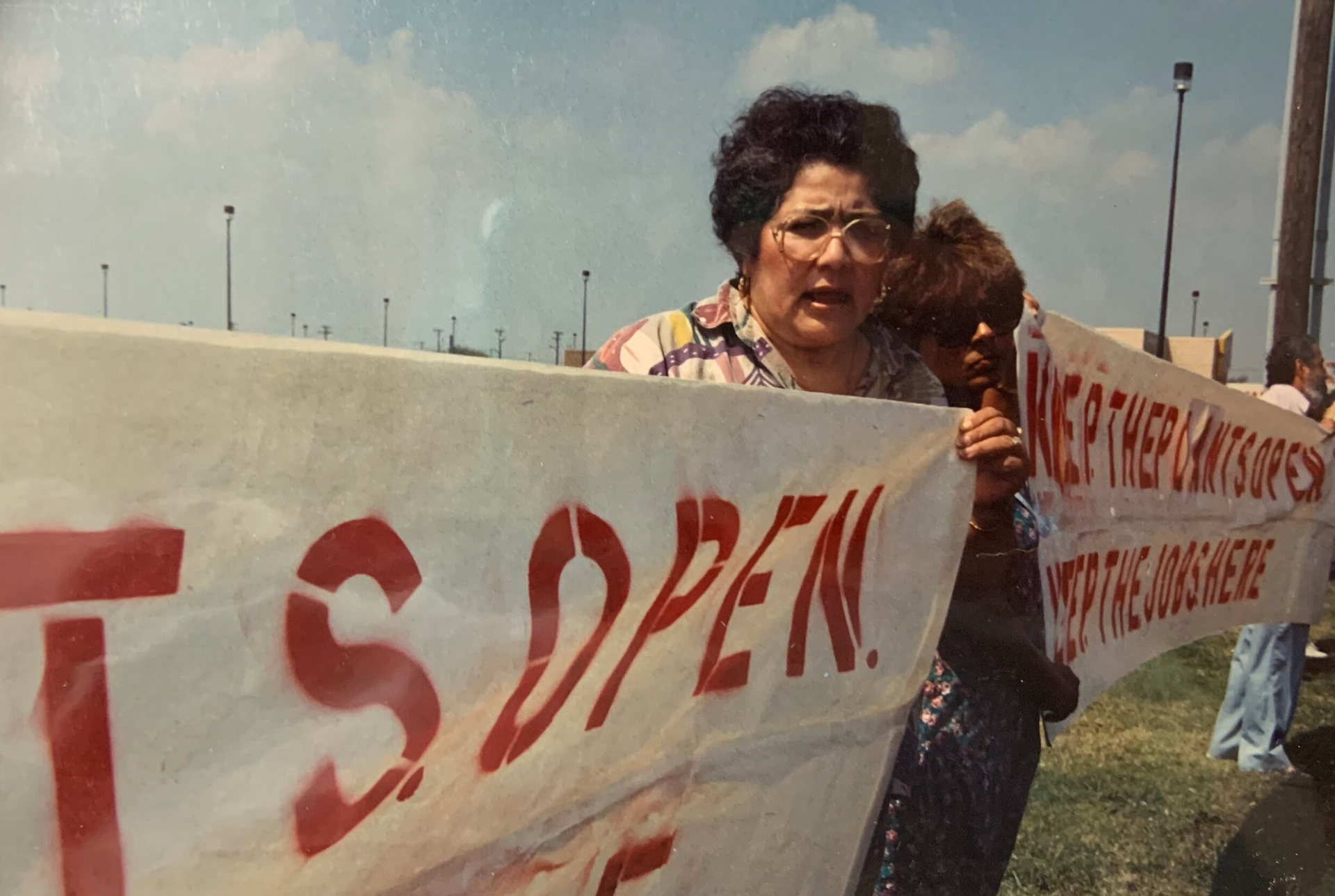 A woman is holding a sign that says ts open