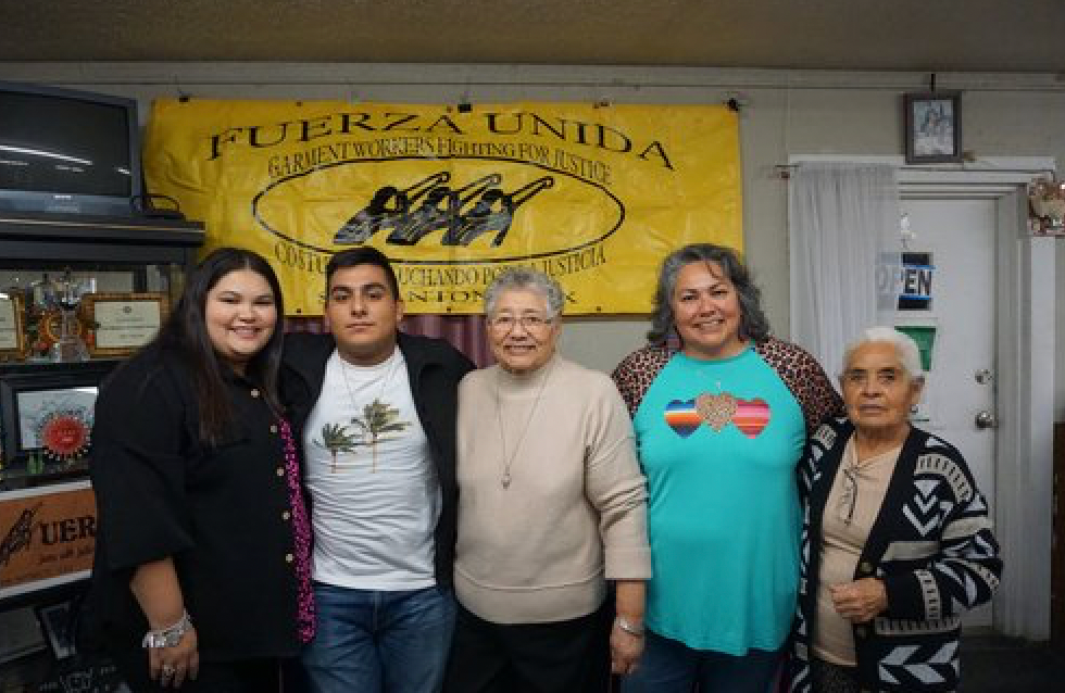 A group of people are posing for a picture in front of a yellow banner.