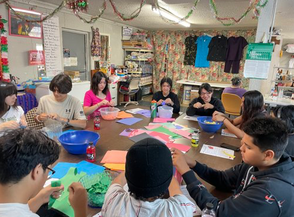 A group of people are sitting around a table making crafts.