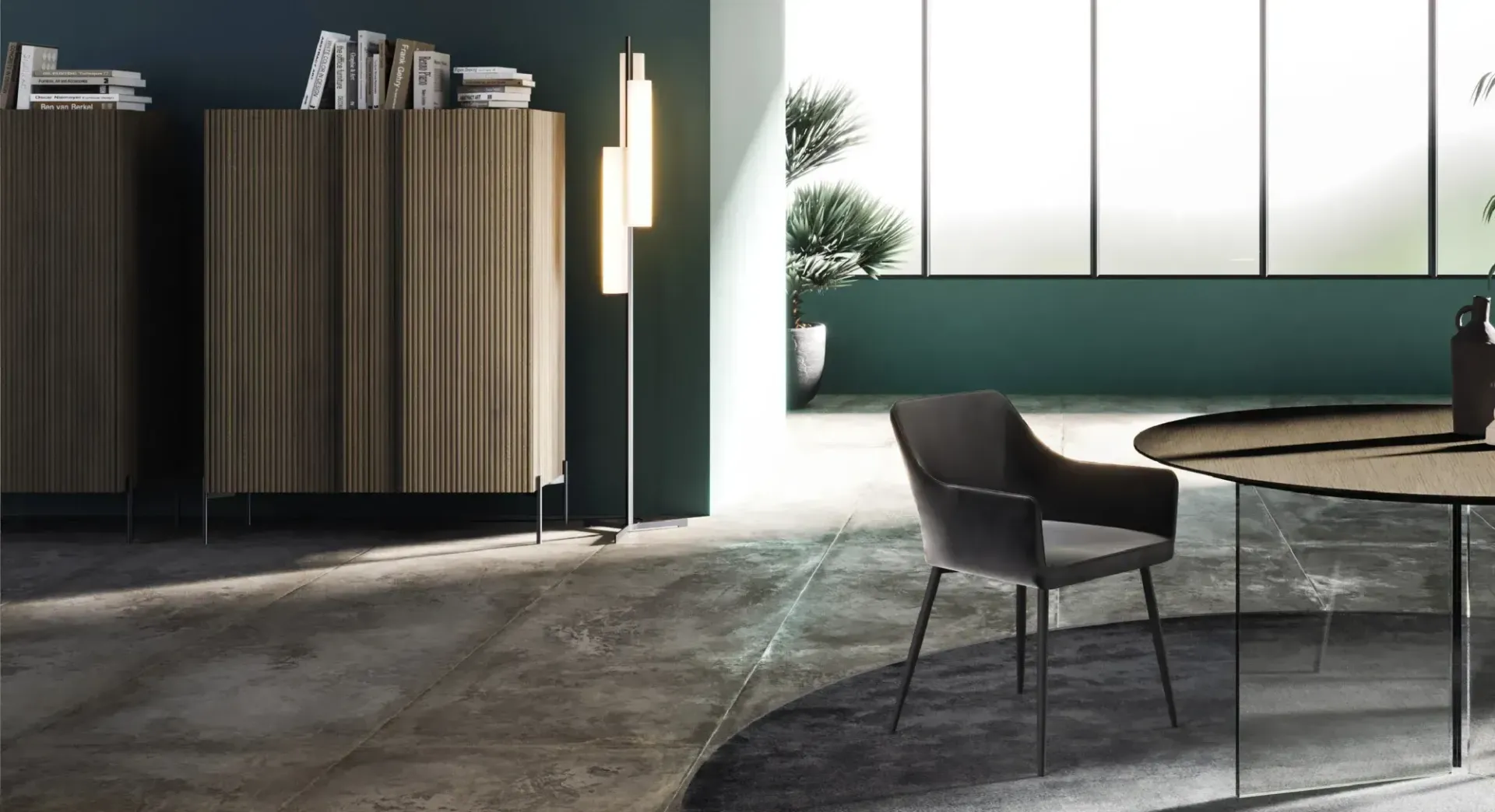 Sala da pranzo moderna con sedie scure, tavolo rotondo e ampia parete finestrata, con mobiletto in legno e lampada da terra.