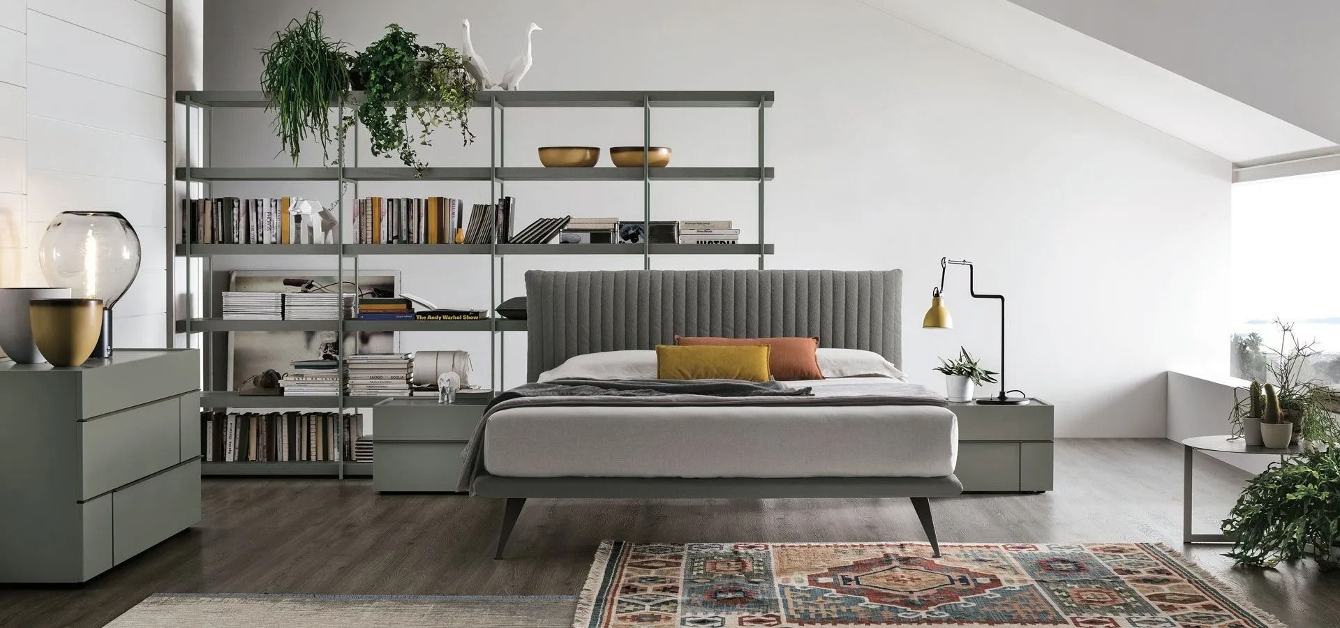 Camera da letto moderna e minimalista con letto grigio, mensole, piante