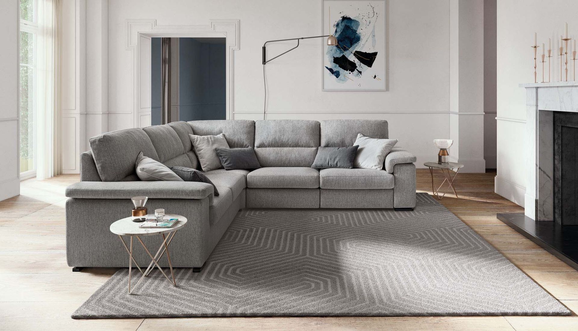 Soggiorno moderno con divano componibile grigio, tappeto e opere d'arte alle pareti in uno spazio luminoso e minimalista.