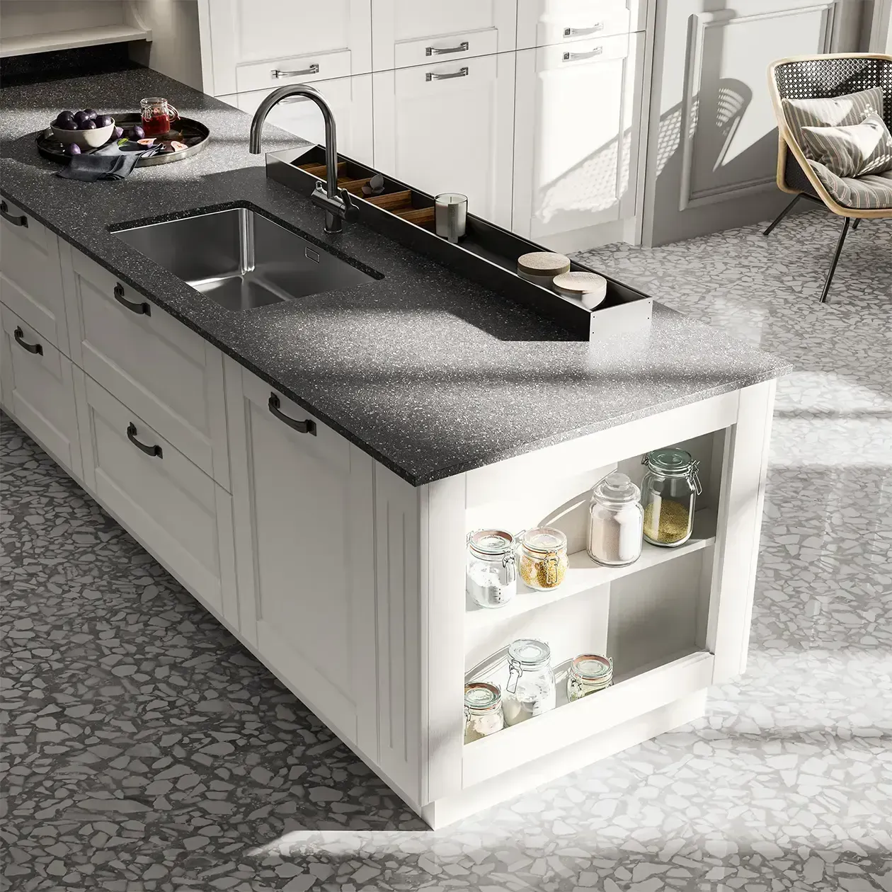 Isola cucina moderna con piano di lavoro nero, doppio lavello, mobili bianchi e mensole a vista per esporre le stoviglie.