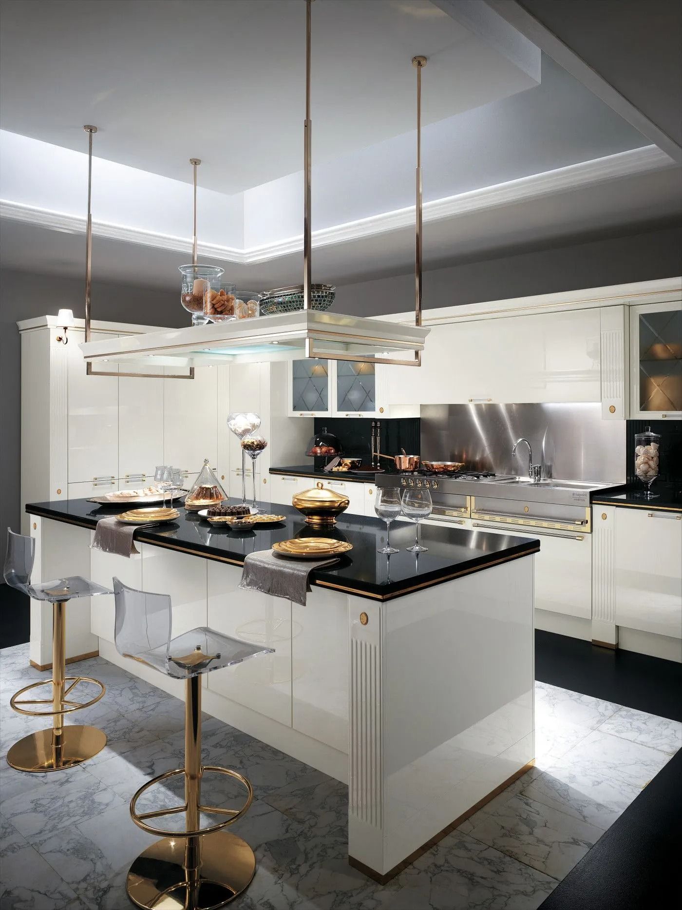 Elegante cucina bianca con isola centrale nera, sgabelli da bar dorati e moderne lampade a sospensione.