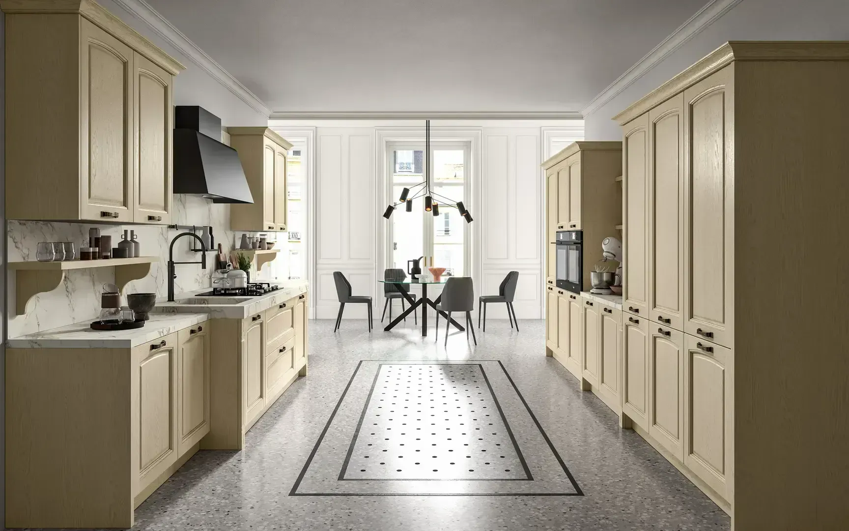 Cucina luminosa e stretta con mobili color crema, isola centrale e tavolo da pranzo accanto a una finestra soleggiata.