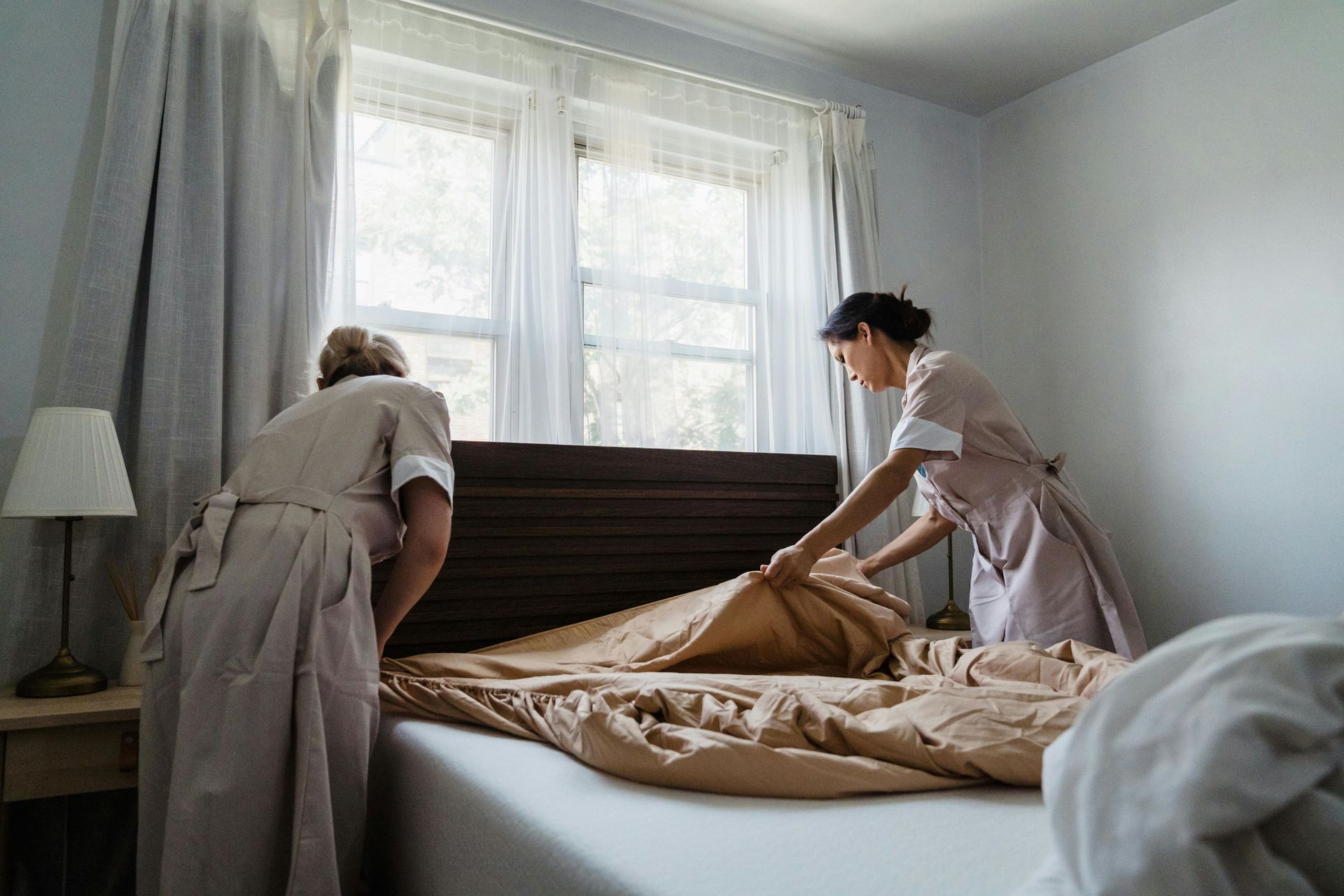 Two female workers are fixing a bed.