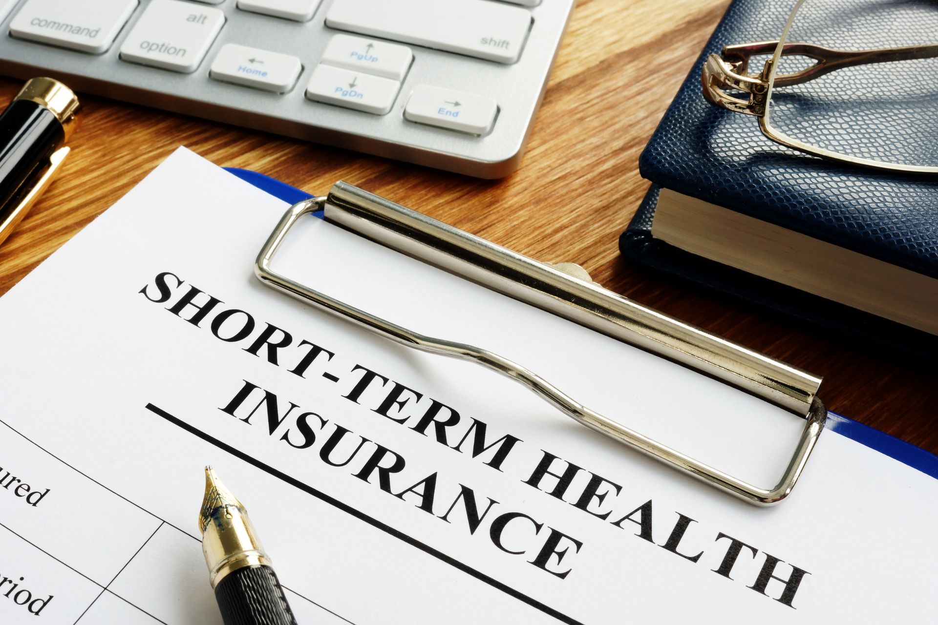 A clipboard with short term health insurance written on it
