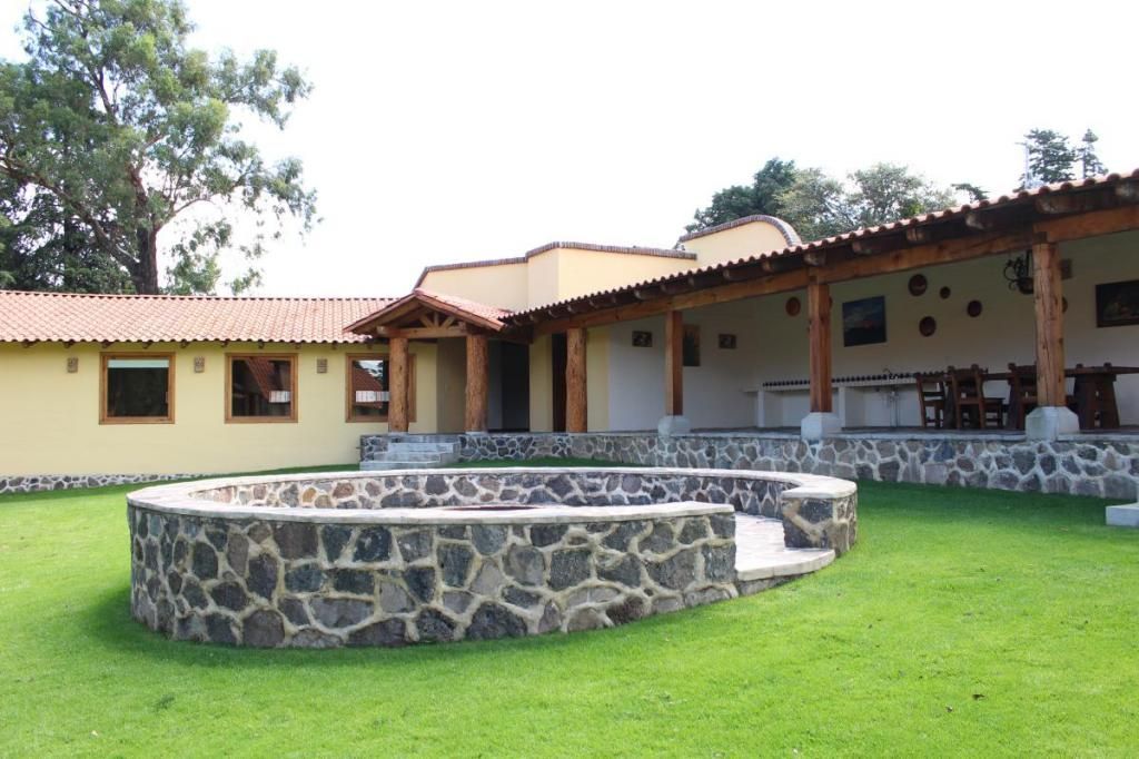 A large house with a stone wall in front of it