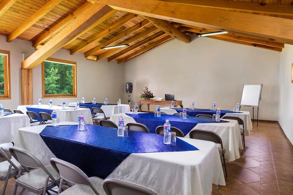A large room with tables and chairs set up for a meeting.