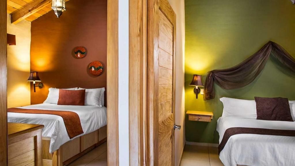 A hotel room with two beds , a dresser , and a closet.