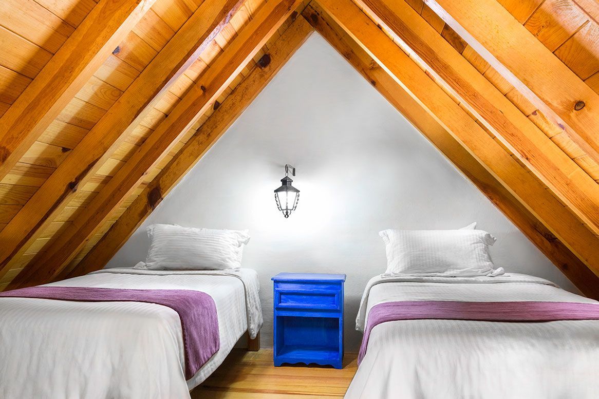 A bedroom with two beds and a blue nightstand
