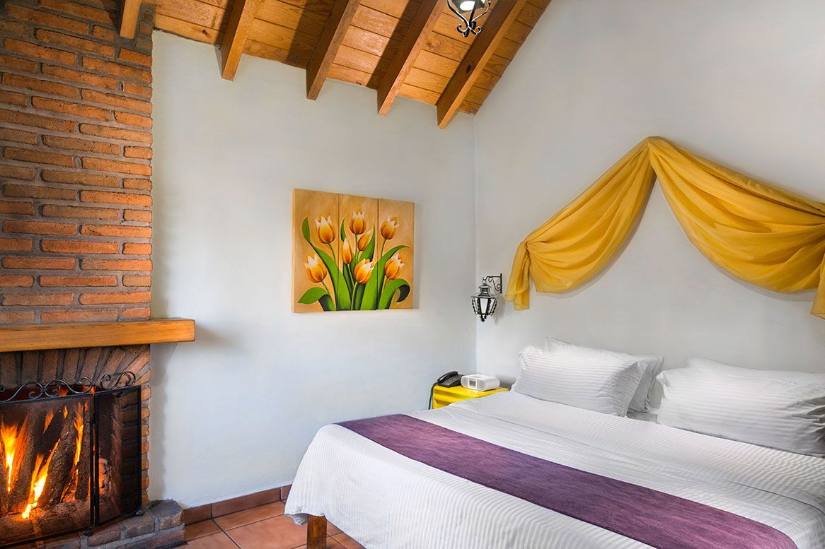 A bedroom with a fireplace and a bed