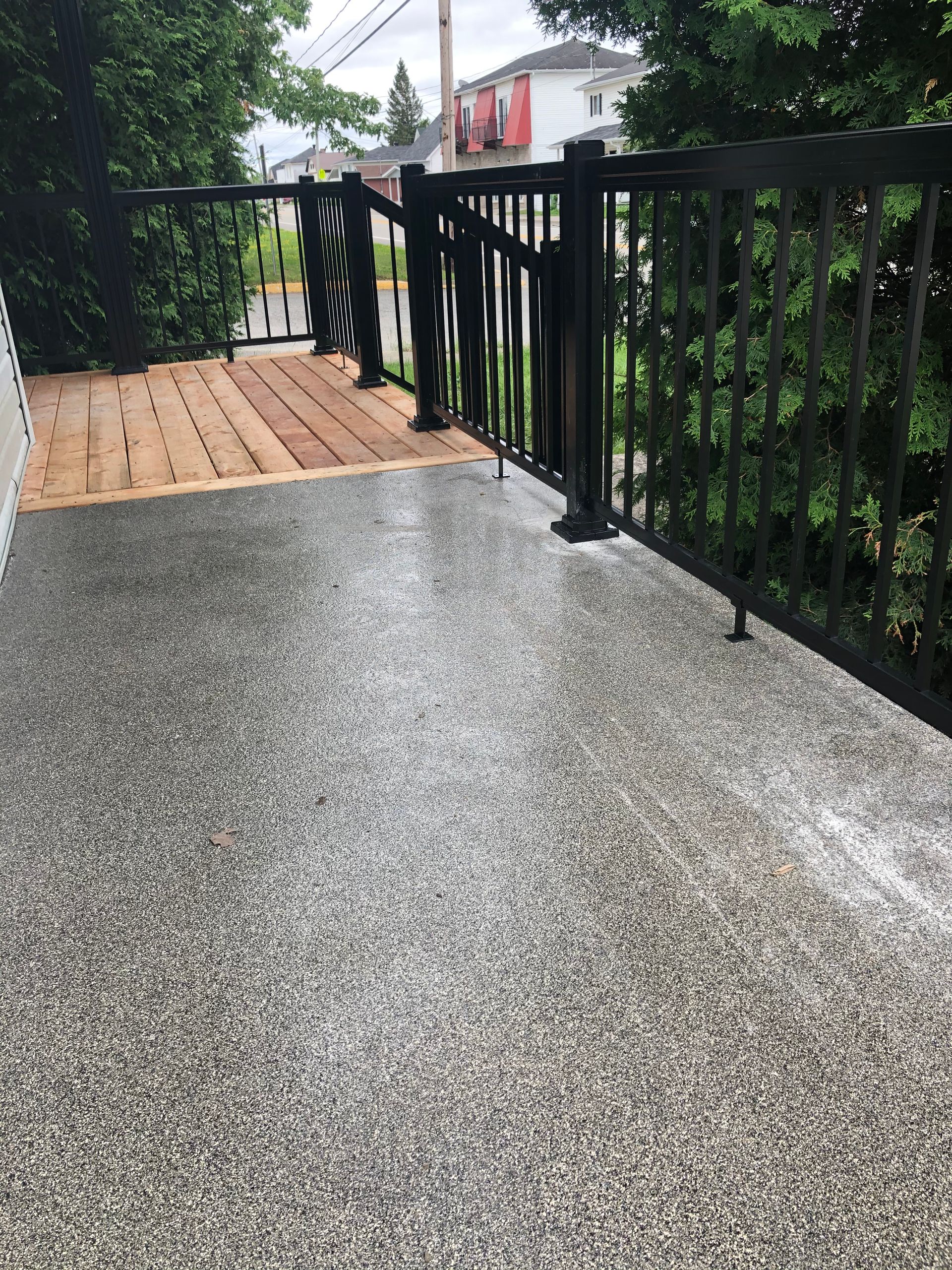 Terrasse extérieure avec surface composite et rambarde noire.