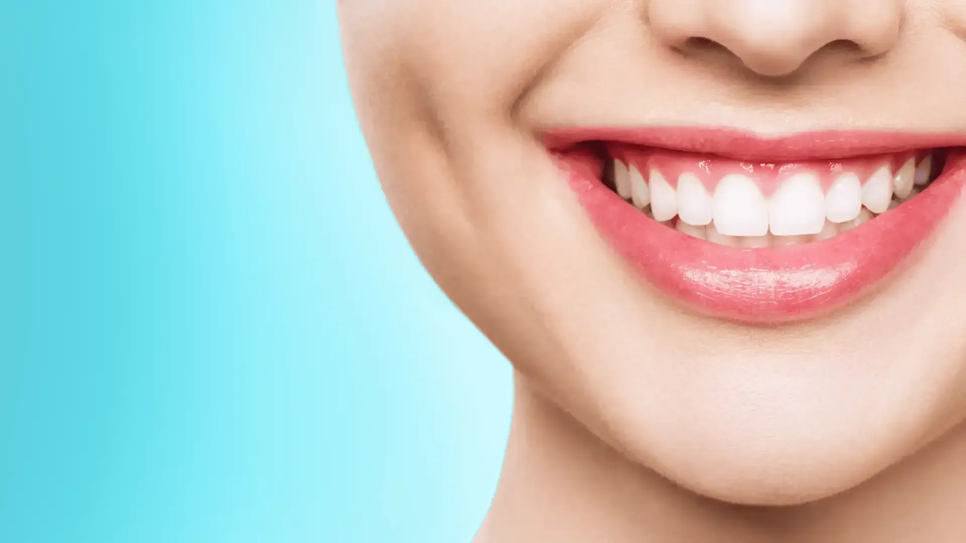 A close up of a woman 's smile with white teeth and pink lipstick.
